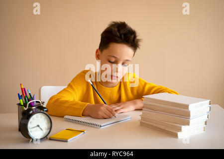 Thinking child bored, frustrated and fed up doing his homework Stock Photo
