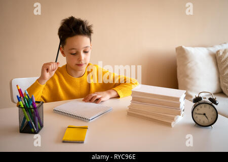 Thinking child bored, frustrated and fed up doing his homework Stock Photo