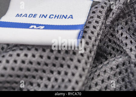 Made in China clothing label stitched into garment. For Chinese export-imports, US-China tariffs, Chinese textiles, offshoring to China, foreign trade Stock Photo