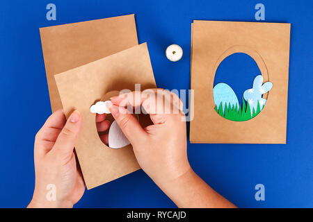 Diy Easter cards from paper. Volume greeting cards with a bunny, egg on blue background. 3d. Gift idea, decor Spring, Easter. Step by step. Top view.  Stock Photo
