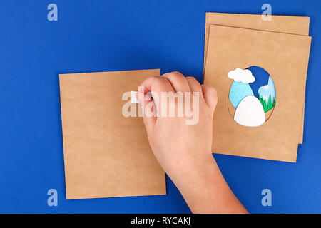 Diy Easter cards from paper. Volume greeting cards with a bunny, egg on blue background. 3d. Gift idea, decor Spring, Easter. Step by step. Top view.  Stock Photo