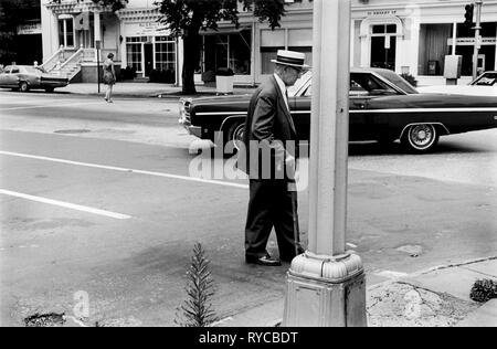 Princeton New Jersey USA 1969. An old man  crosses the street using a walking stick and  wearing a Panama hat Nassau street, 1960s 60s US HOMER SYKES Stock Photo