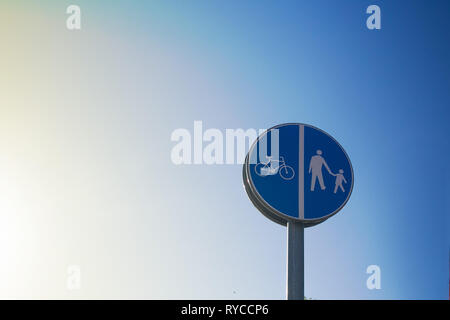 Road sign informing about cycle path and footpath ahead with a blue sky background Stock Photo