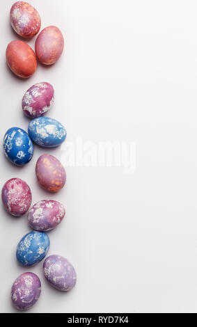 Free space right border background with blue, pink and purple easter eggs with copy space for text, isolated on white background. Flat lay, top view.  Stock Photo