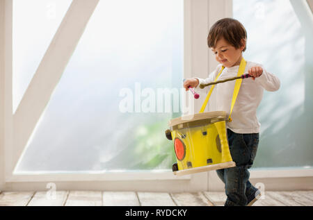 Toddler boy playing with his toy drum. Stock Photo