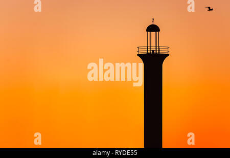 The sun sets on the Broadwater Beach Marina channel lighthouse, Feb. 24, 2019, in Biloxi, Mississippi. Stock Photo