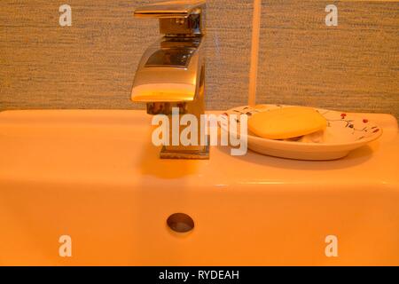 Modern faucet and classic soap dish on white basin.  Minimalist concept. Stock Photo