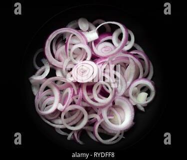 Sliced red onions on a black background. Stock Photo