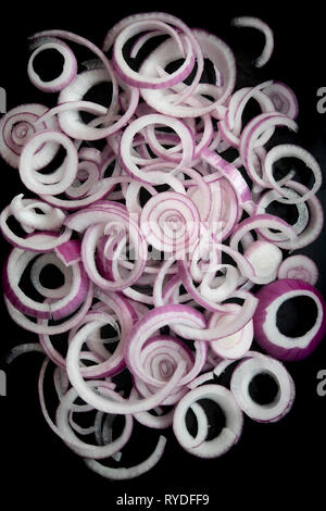 Sliced onion rings on a black background. Stock Photo