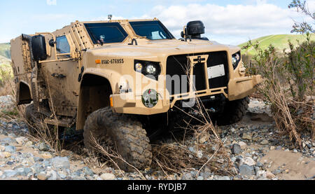 A Joint Light Tactical Vehicle displays its ability to handle multiple terrain types by physically adjusting its suspension during a demonstration at the School of Infantry West, Marine Corps Base Camp Pendleton, California, Feb. 27, 2019. Marines are able to adjust multiple drive settings of the JLTV by selecting options on an internal LCD. These settings affect how the vehicle drives in sandy, muddy, snowy or highway road conditions. The JLTV consists of multiple platforms capable of completing a variety of missions while providing increased protection and mobility for personnel across the M Stock Photo