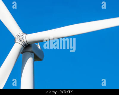Detail of a large horizontal axis wind turbine in motion with tower rotor blades and nacelle which houses the electricity generator - South Wales UK Stock Photo