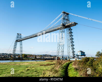 Newport Transporter Bridge spanning the River Usk in South Wales carries vehicles and passengers across the river whilst allowing masted boats beneath Stock Photo