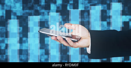 Businessmans Hand in Black Suit Holding Smartphone in Hand Against Futuristic Background Stock Photo