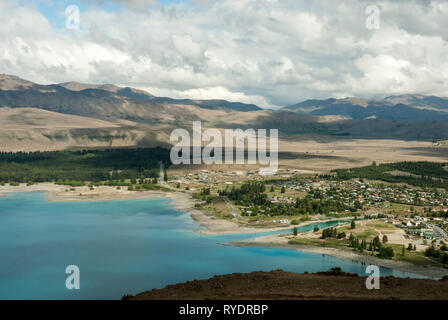 Lake Tekapo town, New Zealand, situated beside pale blue lake Tekapo and set amongst mountains; view from Mount John on a sunny spring day. Stock Photo