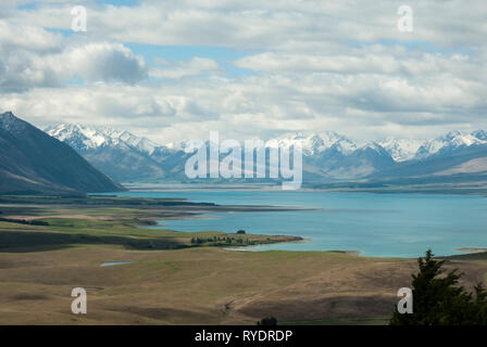 Sunning pale blue Lake Tekapo, NZ with snow capped Southern Alps in the background on a sunny day in spring. Stock Photo