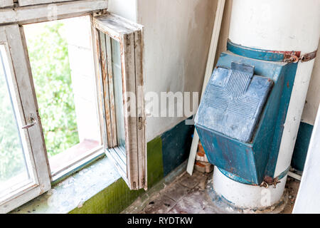 Inside stairway corridor in old Soviet apartment building in Ukraine summer with dirty run-down open window interior floor with trash chute Stock Photo