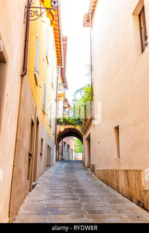 Chiusi, Italy narrow street alley with arch in small historic medieval town village in Umbria vertical view during day with orange yellow bright vibra Stock Photo