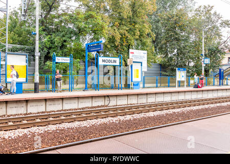 Warsaw, Poland - September 6, 2018: Architecture of modern train station platform with people waiting with luggage in historic Polish city in summer d Stock Photo