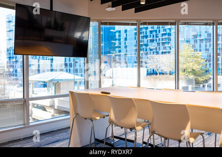 Modern office in building with wooden meeting corporate business table with television screen and chairs empty nobody Stock Photo