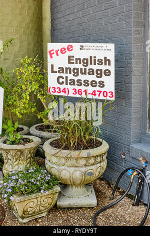 English language classes sign in a flower pot near a busy sidewalk in Prattville Alabama, USA. Stock Photo