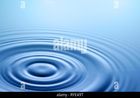 Tranquil scene. Symmetrical smooth circles and waves on water surface after splash. Stock Photo