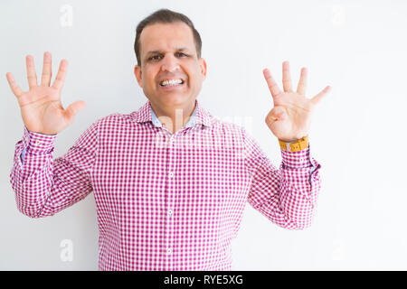 Middle age man wearing business shirt over white wall showing and pointing up with fingers number nine while smiling confident and happy. Stock Photo