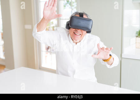 Man wearing virtual reality glasses smiling looking very happy and excited Stock Photo