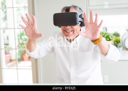 Man wearing virtual reality glasses smiling looking very happy and excited Stock Photo