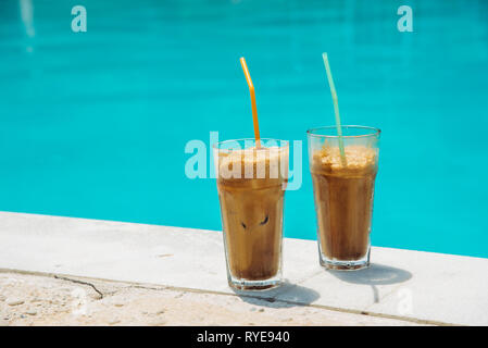 Two glass of iced frappe near the swimming pool. Stock Photo