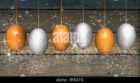 Text 'Easter' on gold and silver eggs which hang on rope with glitter powder on wood background