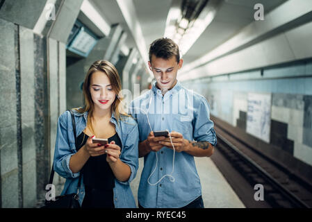 Phone addict couple using gadget in subway Stock Photo