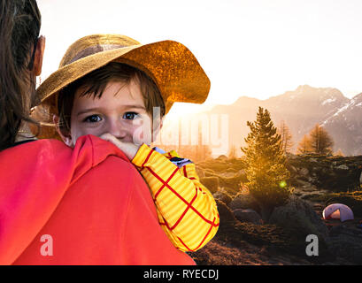 Families and sons camping on woods. Mother, mothers holding son in arms. Little boy, kid, child, children looks at camera happily. Family activities Stock Photo