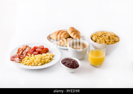 Breakfast with scrambled eggs, bacon, tomatoes,coffee,orange juice ,croissant and corn flakes isolated on white background. Stock Photo