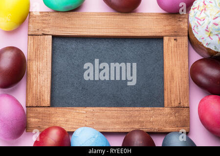 Colorful Easter eggs as an attribute of Easter celebration. Pink background. Stock Photo