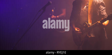 Rock and roll music panoramic background photo, guitar players on a stage, soft selective focus Stock Photo
