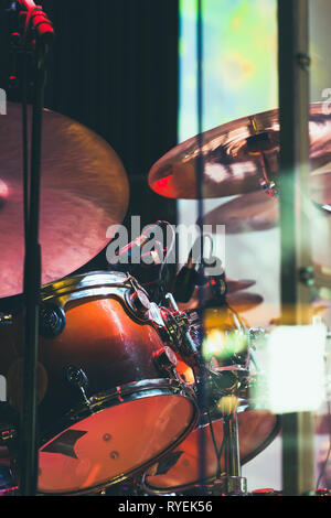 Drum set on a stage with colorful illumination, life rock music vertical photo background Stock Photo