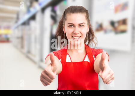 Female supermarket or hypermarket employee making double thumbs-up as like gesture with happy expression Stock Photo