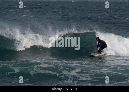 Surfer on Gyllyngvase beach, Falmouth in three to four foot surf Stock Photo
