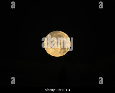 Full Moon named Cold Moon rising on black background Stock Photo