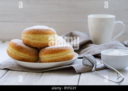 Traditional German Polish Donut with Raspberry Jam Dusted with Icing Sugar Stock Photo