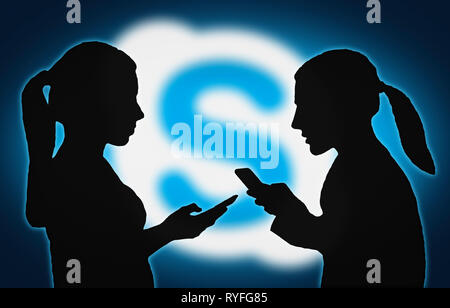 Silhouettes of group of people with mobile devices using the Skype app. Stock Photo