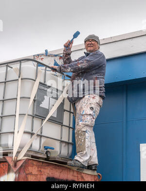 Man painting a building, Qaqortoq, South Greenland Stock Photo