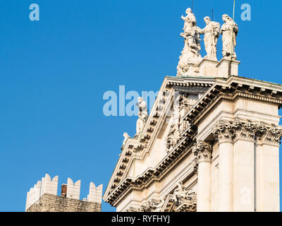 Travel to Italy - pediment of Duomo Nuovo (The New Cathedral, Cattedrale estiva di Santa Maria Assunta) and top of Broletto tower on square Piazza Pao Stock Photo