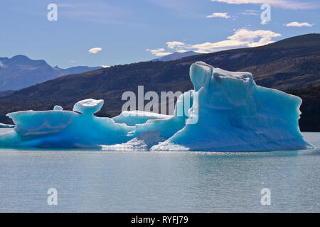 Large blue bright icebergs float on the waters of Lago Argentino lake, El Calafate, Argentina in sunshine day. Stock Photo