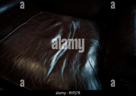 Close up of crinkled comfortable dark leather chair cushion seating Stock Photo
