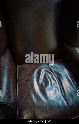 Close up of crinkled comfortable dark leather chair cushion seating Stock Photo