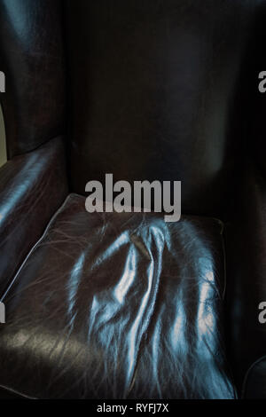 Close up of crinkled comfortable dark leather chair cushion seating Stock Photo