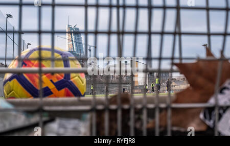 Football being played in inner city urban space above a car perk Stock Photo