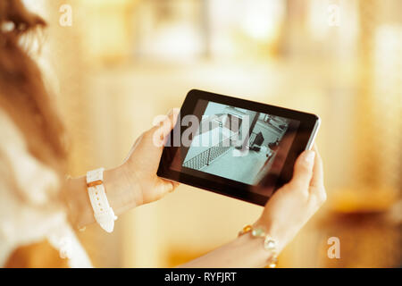 Closeup on tablet PC with video from security camera in hands of modern housewife at home. Stock Photo