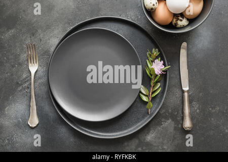Elegance easter table setting with spring pink flowers on dark. Easter romantic dinner. Top view. Stock Photo